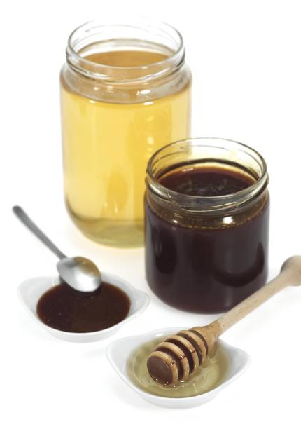 istock Honey and Treacle Jars against White Background 1254520379