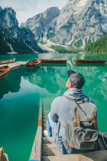 istock man with backpack looking at fabulous view of mountain lake 1254520642
