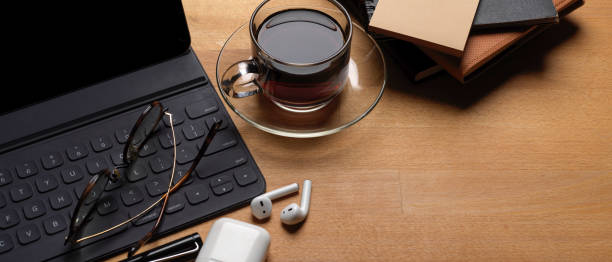 istock Rustic worktable with digital tablet, glasses, wireless earphone, schedule books and coffee cup 1254520855