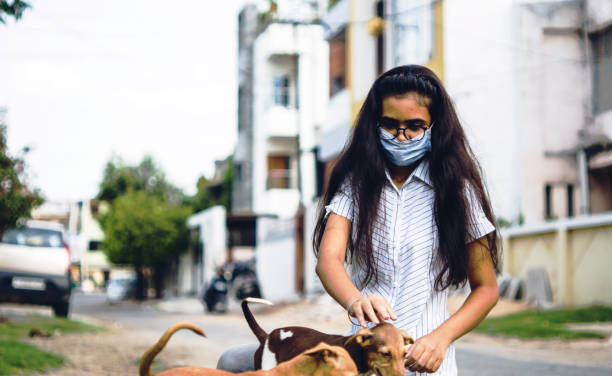 istock girl playing with puppies 1254525373