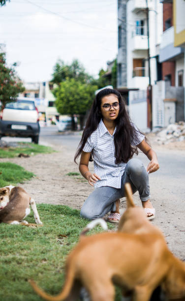 istock girl playing with puppies 1254525410