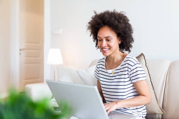 istock Beautiful woman freelancer noting information for planning project doing remote job via laptop computer. Girl laughing while reading email on modern laptop device . 1254525733