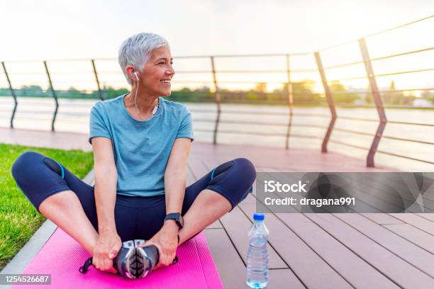 Mujer En Una Estera De Yoga Para Relajarse Al Aire Libre Foto de stock y más banco de imágenes de Estilo de vida saludable