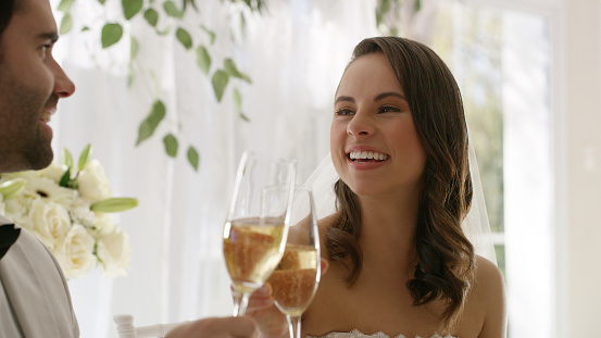 Shot of a happy young couple enjoying a glass of champagne at their wedding reception