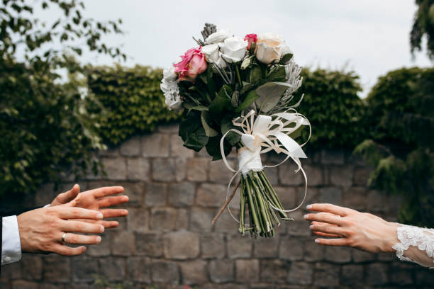 Wedding bouquet flying to hands on green background