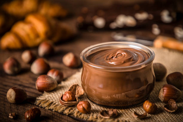 хрустальная банка, полная фундука и шоколада распространения - dessert sweet food brown chocolate стоковые фото и изображения