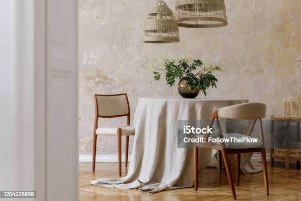 Stylish And Elegant Dining Room Interior With Diner Table Design Chairs Rattan Pendant Lamps Dried Flowers In Vases Furniture Decoration And Elegant Personal Accessories In Cozy Home Decor Stock Photo - Download Image Now