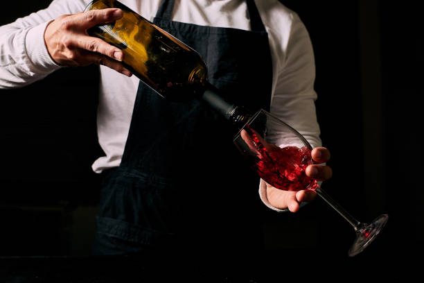 istock a man pours wine into a glass 1254528941
