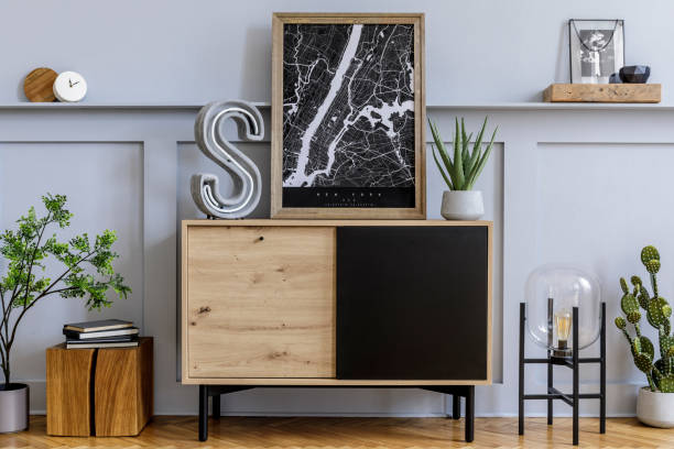 istock Modern scandinavian home interior with mock up poster frame, design wooden commode, big cement letter, cacti, plants, decoration, shelf and personal accessories in stylish home decor. 1254530641
