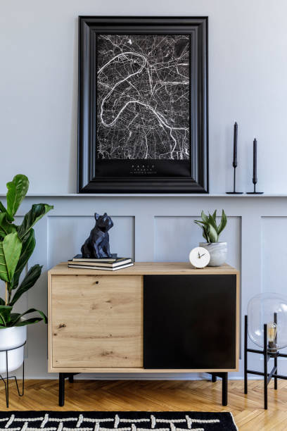 istock Modern scandinavian home interior with mock up poster frame, design wooden commode, cacti, plants, decoration, shelf, candlestick, book and personal accessories in stylish home decor. 1254530919