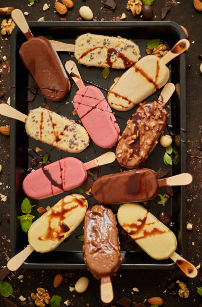 istock Assortment of various popsicle ice cream, white and dark chocolate, with almonds, rusty background 1254531299