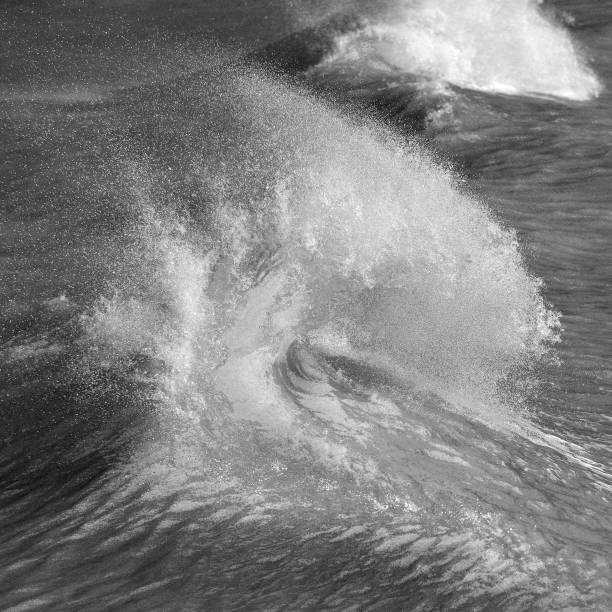 istock Amzing image of individual wave breaking and cresting during violent windy storm in black and white with superb detail 1254531460