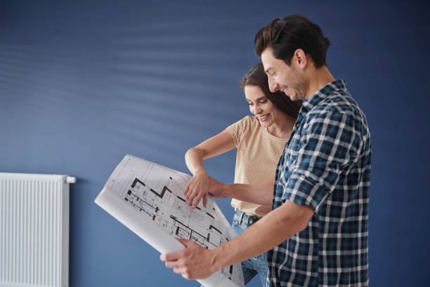 istock Side view of couple browsing  a home blueprint 1254531967