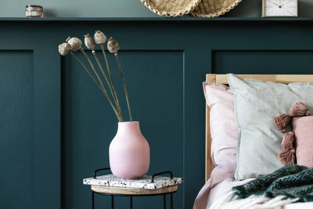 istock Modern bedroom interior with design coffee table, flowers in vase and elegant personal accessories. Beautiful bed sheets, blanket and pillows. Template. Stylish home staging. 1254532124