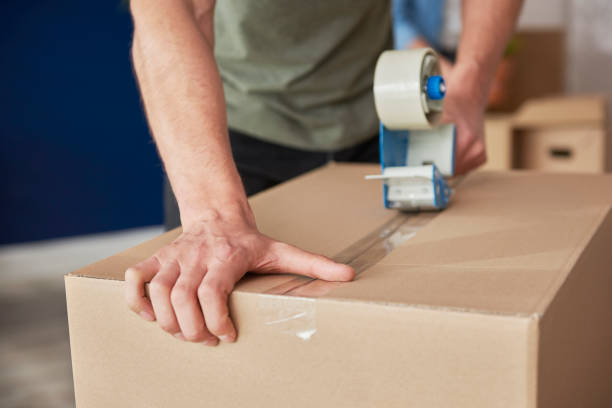 istock Detail of packing cardboard boxes while moving house 1254532234