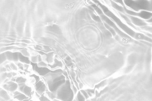 desaturated transparent clear calm water surface texture Closeup of desaturated transparent clear calm water surface texture with splashes and bubbles. Trendy abstract nature background. White-grey water waves in sunlight. skin care photos stock pictures, royalty-free photos & images