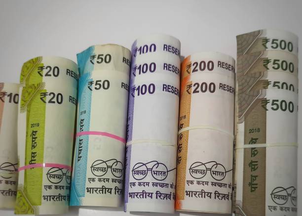 istock New Indian rupees currency notes rolls with rubber band randomly with rupees coins in white paper 1254533925