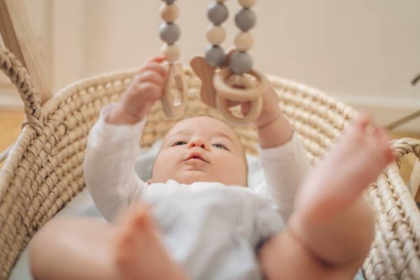 Baby playing with mobile made of wood