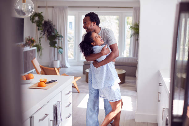 istock Loving Couple Wearing Pyjamas Hugging In Kitchen At Home Together 1254537308