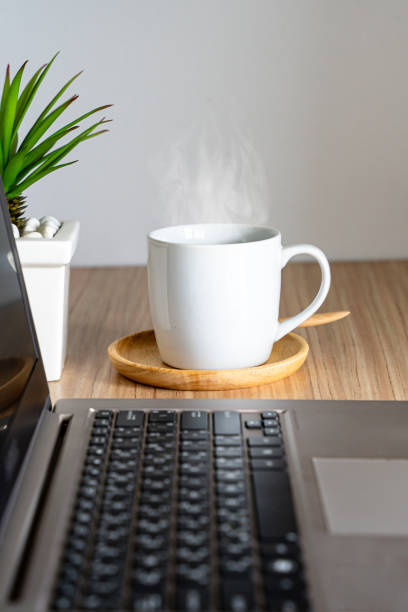 istock Cup of hot coffee and laptop computer. Business concept 1254539169