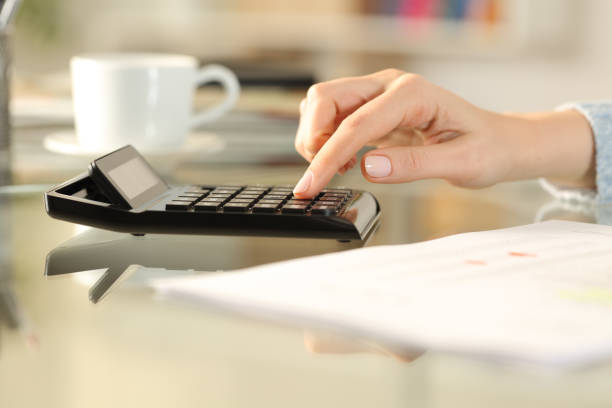 istock Woman hands calculating on calculator at home desk 1254540954