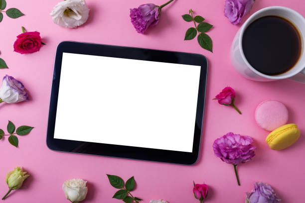 istock digital tablet with blank screen on pink background with flowers and coffee cup. top view 1254542000
