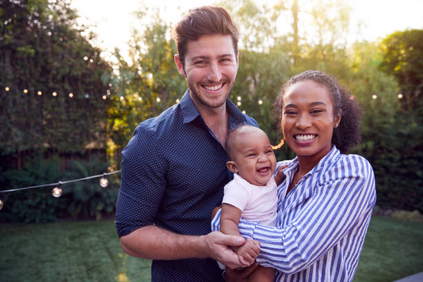 porträt der familie mit baby sohn zu hause im freien im garten - beide elternteile fotos stock-fotos und bilder