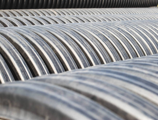 istock Large diameter black polypropylene pipes for laying communications, drainage systems and heating mains under the road. Modern method and technology for supplying water and sewage, copy space, industry 1254543846