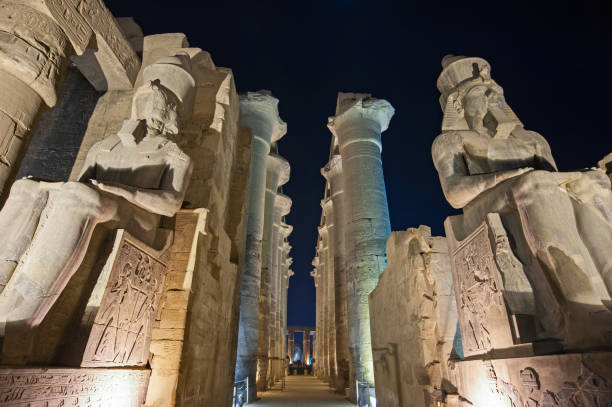 istock Statues and columns in hypostyle hall at Luxor Temple during night 1254546635