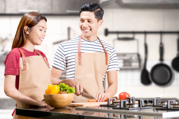 Asian couple cooking food with kitchenware Asian couple cooking food with kitchenware on the kitchen room malay couple stock pictures, royalty-free photos & images