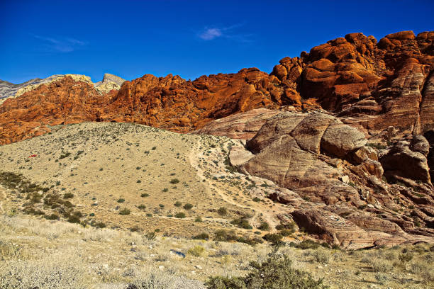 レッドロックキャニオン州立公園は、美しい砂漠の崖、ビュート、壮大な岩層を備えています。公園はシエラネバダの南端がエルパソ山脈と収束する場所に位置しています。 - usa dirt road rock sandstone ストックフォトと画像