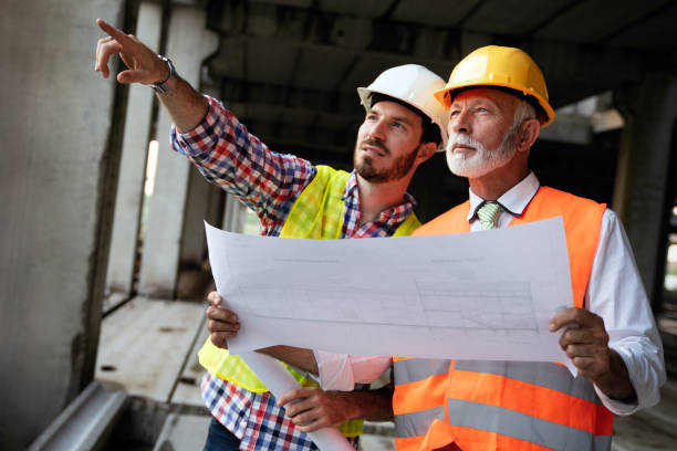 istock Architect and construction engineer or surveyor discussion plans and blueprints 1254551443