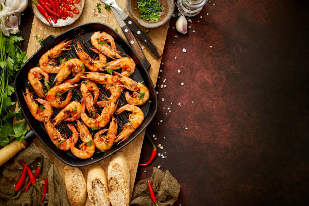 istock Tasty appetizing roasted shrimps prawns with spices on pan with ingredients on rusty background 1254552372