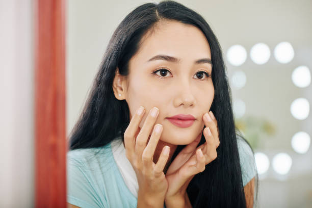 istock Woman looking at herself in mirror 1254553121