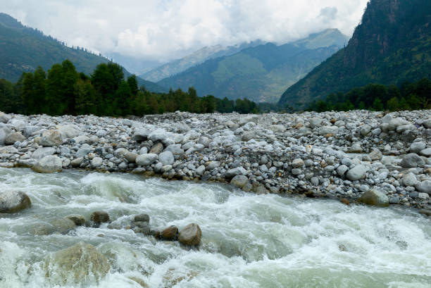istock River flows through valley flanked by rocks in Manali, India. 1254553446
