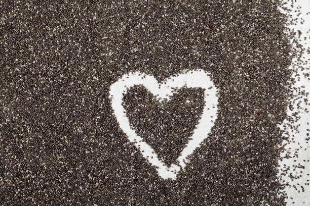 istock Background of organic chia seeds with white heart shaped frame inside. 1254559604