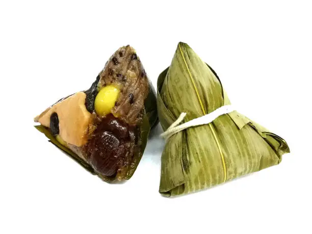 Photo of Sticky rice dumpling or Zongzi (Pyramid-shaped dumpling made by wrapping glutinious rice in bamboo leaves) Isolated on white.