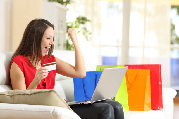 istock Excited shopper paying on laptop with card at home 1254559980