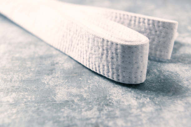 istock White karate belt on rustic wooden background. Close up. Copy space. 1254560040