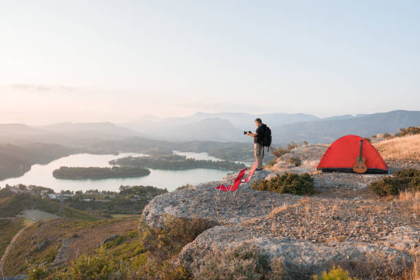 istock Photographer man camping on the mountain peak 1254561010