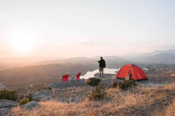 istock Photographer man camping on the mountain peak 1254561041