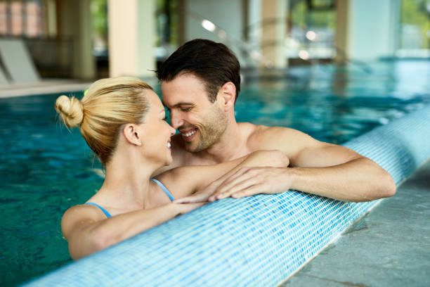 istock Happy couple in love showing affection while swimming in the pool. 1254562251