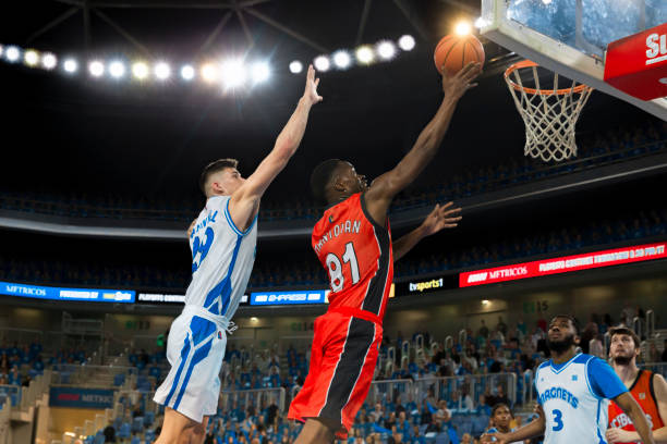 istock Basketball player slam dunking ball 1254564793