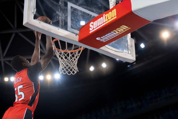 istock Basketball player slam dunking ball 1254565501
