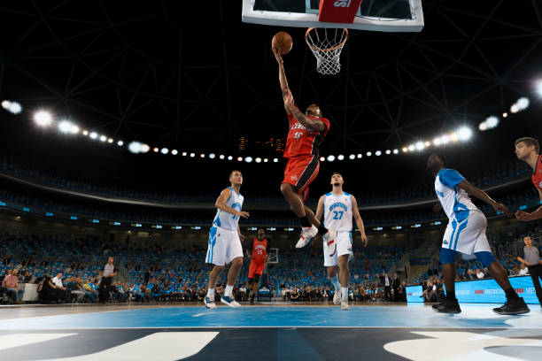 Basketball player slam dunking ball Basketball player in red jersey slam dunking ball during the match. basketball ball photos stock pictures, royalty-free photos & images