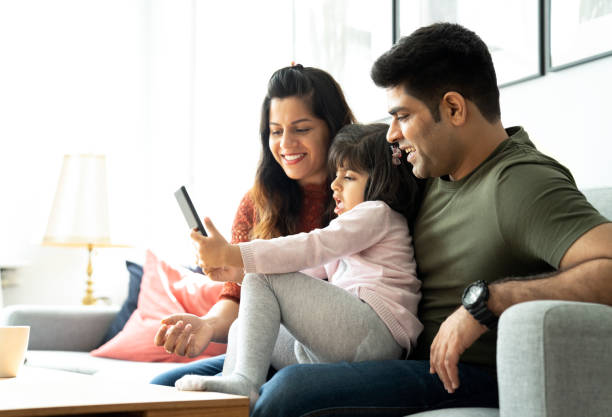 istock Happy parents sitting with daughter taking selfie 1254567349