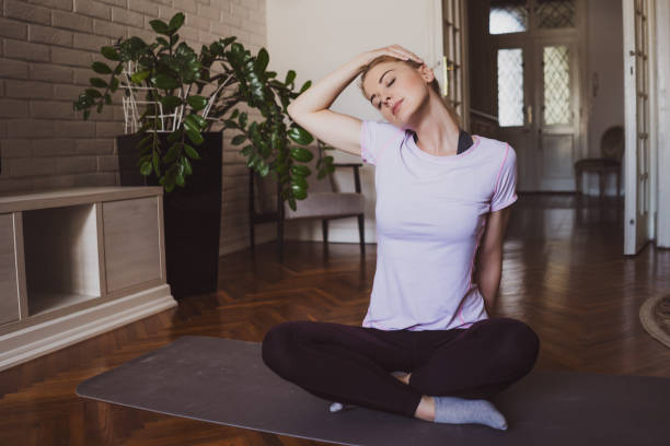 Woman exercising at home Young beautiful woman practicing pilates and yoga exercises at home. neck stock pictures, royalty-free photos & images