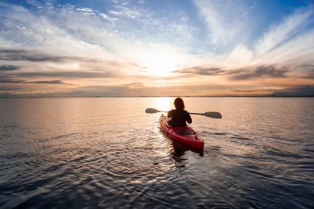 Photo of Sea Kayaking in calm waters during a colorful and vibrant sunset.