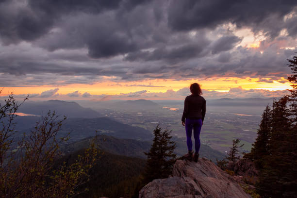 istock Fantasy Adventure Composite with a Man on top of a Mountain Cliff 1254568238