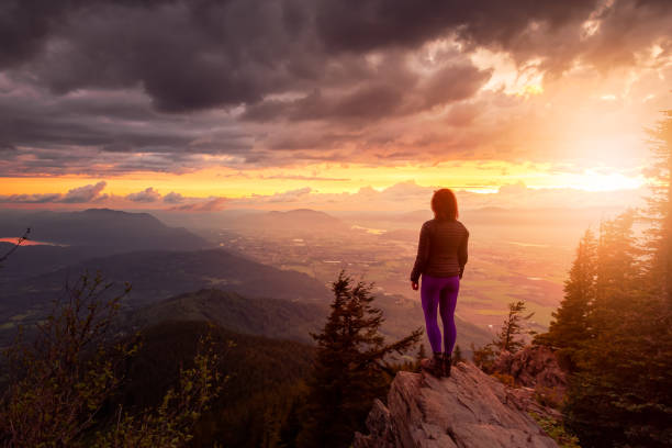 istock Fantasy Adventure Composite with a Man on top of a Mountain Cliff 1254568351
